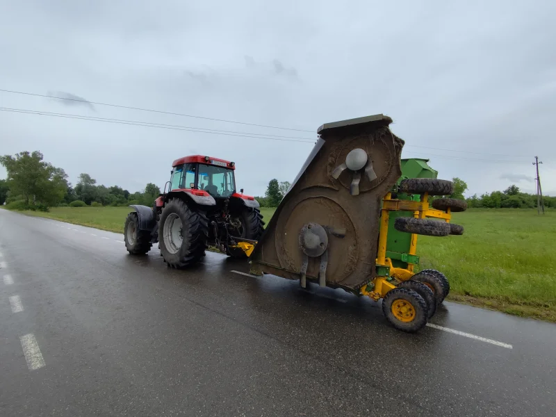 Pievų smulkinimas traktoriumi su mulčeriu kelyje Utenos rajone